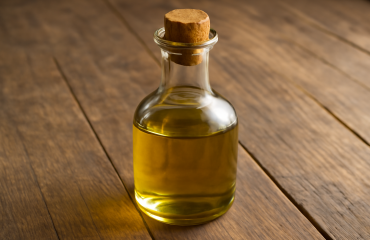 flacon d'huile pose sur une planche en bois