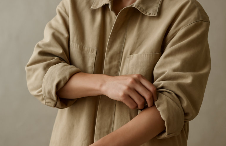 personne retroussant manches d'une veste oversize