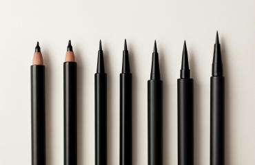 différents eyeliners alignés sur une surface claire