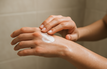 mains appliquant une crème après la douche