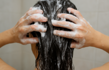 mains appliquant shampooing sur cheveux mouilles