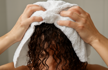 mains essorant cheveux bouclés avec serviette