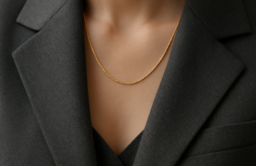 collier discret et montre posés sur veste