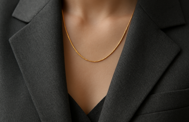 collier discret et montre posés sur veste