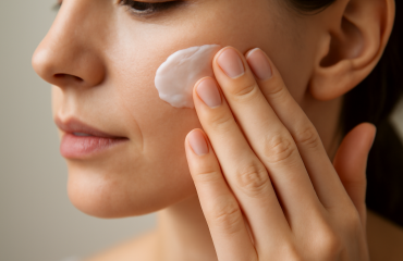 main appliquant une crème sur joue
