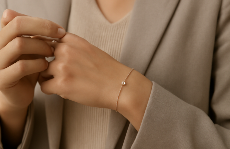 main ajoutant bijou discret à tenue neutre