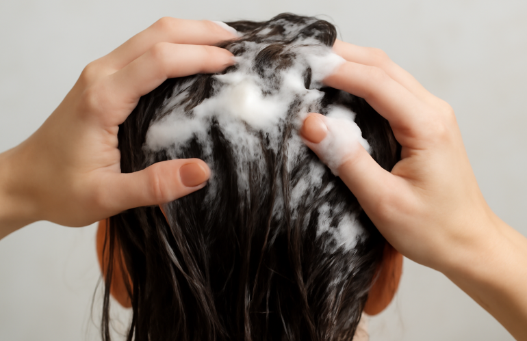 mains appliquant une mousse légère sur cheveux