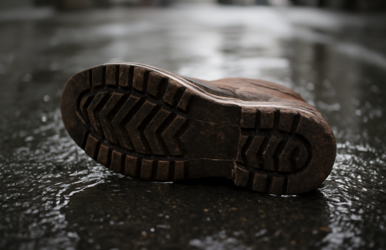 semelle chaussure posée sur sol mouillé urbain