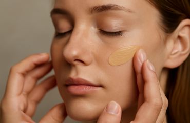 mains appliquant crème teintée sur visage