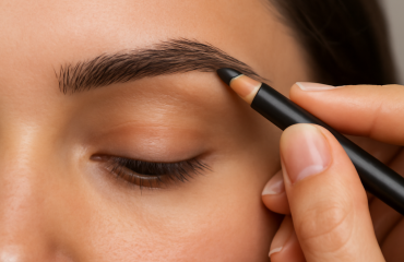 mains remplissant sourcil avec crayon doux