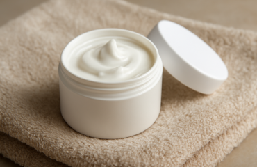 pot de crème posé sur serviette de bain