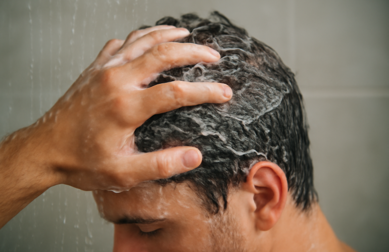 main massant un cuir chevelu sous la douche