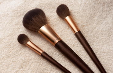 trois pinceaux maquillage posés sur une serviette